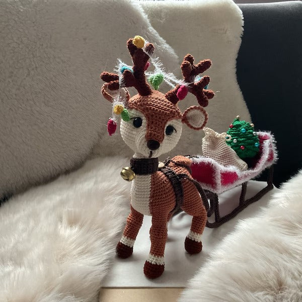 Reindeer with a sleigh a bag for gifts and Christmas tree