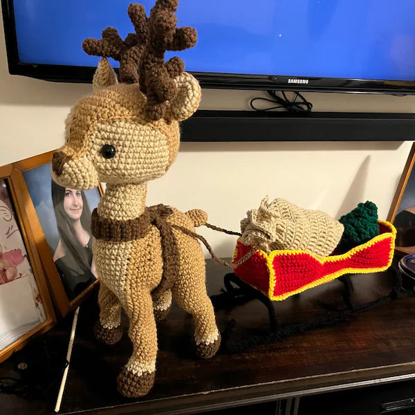 Reindeer with a sleigh a bag for gifts and Christmas tree